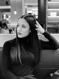 Woman looking away while sitting on bench