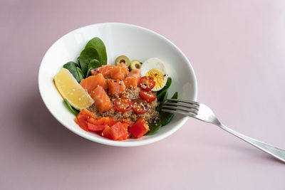 Bowl plate with poke dish. fresh salmon, quinoa, spinach, lemon for a healthy diet. copy space.