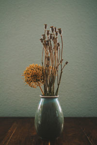 Close-up of vase on table against wall