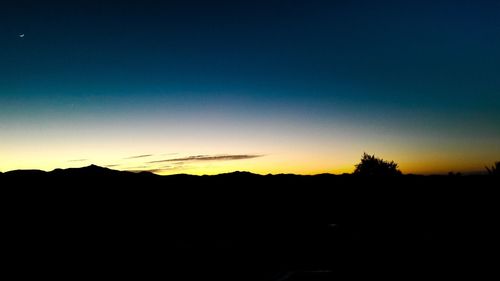 Silhouette landscape against clear sky during sunset