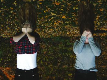 Full length of happy girl standing against autumn leaves