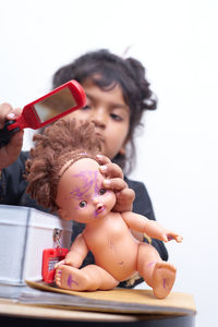 Cute girl holding toy while sitting in container