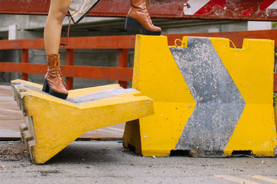 Low section of woman standing on barricades at construction site