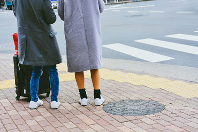 Low section of people standing on road