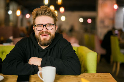 Portrait of young man sitting at restaurant