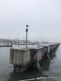 View of sailboats moored in sea against sky