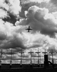 Airplane flying against cloudy sky
