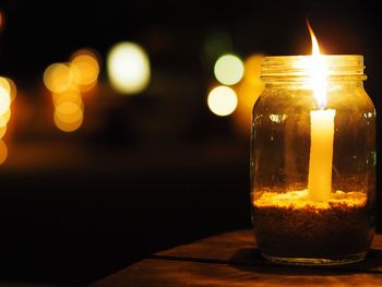 Close-up of lit candle in dark room