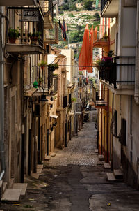 Narrow footpath amidst buildings in city