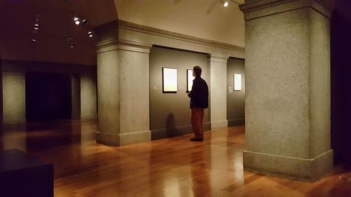 Side view of man standing in corridor of building