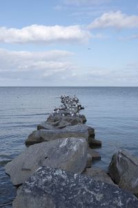 Rocks by sea against sky