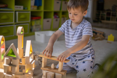 Boy playing with toy blocks at home