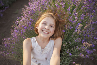 Portrait of a smiling young woman with purple flower