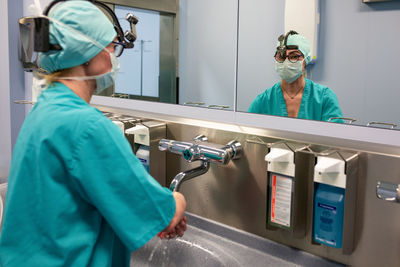 Doctor washing hands over sink