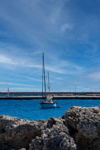 Sailboat sailing on sea against sky