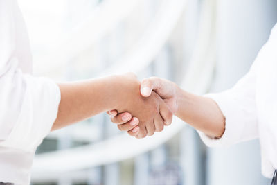 Midsection of friends handshaking 