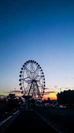 Silhouette ferris wheel against clear sky at sunset