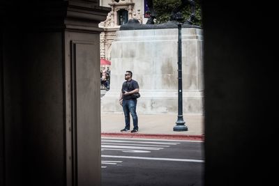 Full length of man standing on road by building