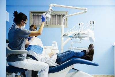 Female dentists examining woman at clinic