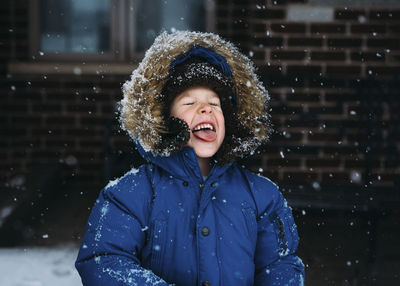 Cheerful boy enjoying snowfall