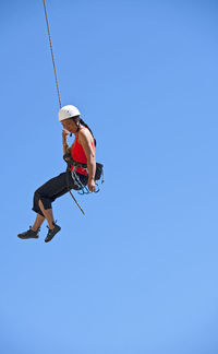 Woman rappelling from rock face in swanage / uk