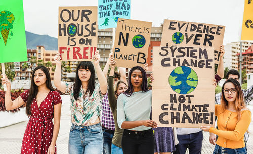 People protesting while standing on street in city