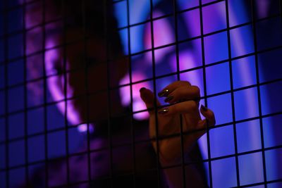 Portrait of woman against chainlink fence