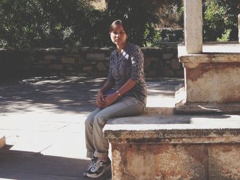 Portrait of smiling young woman sitting on seat