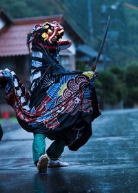 Full length of man wearing costume holding sword on road