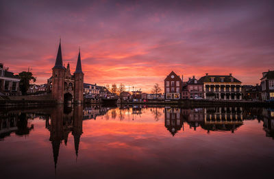 Reflection of buildings in river during sunset