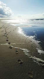 Scenic view of beach against cloudy sky