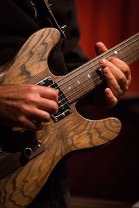 Midsection of man playing guitar