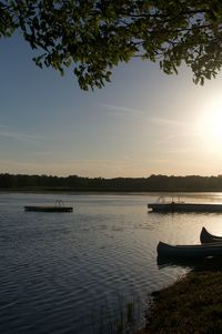 Boat moored in lake against sky during sunset