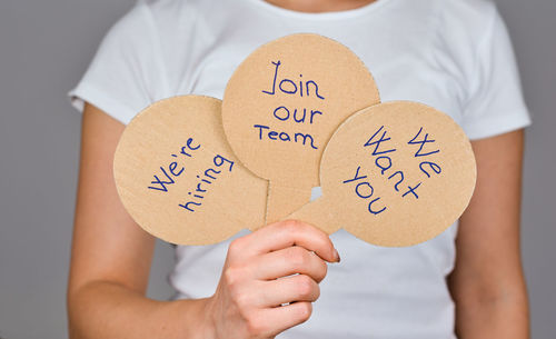 Midsection of man holding paper with text