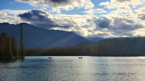 Scenic view of lake by mountains against sky