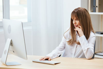 Businesswoman using laptop at table