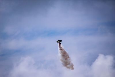 Low angle view of airplane flying against sky