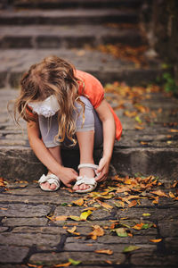 Full length of woman with autumn leaves