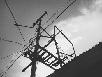 Low angle view of silhouette electricity pylon against sky