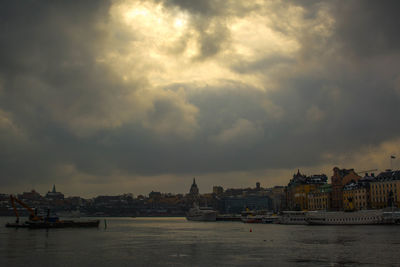 Scenic view of river by buildings against sky in city