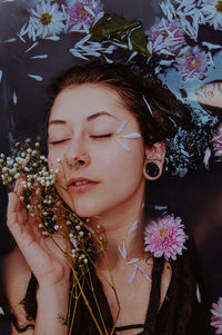 Close-up of woman with eyes closed by pink flowers