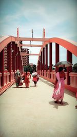 People standing on bridge against sky