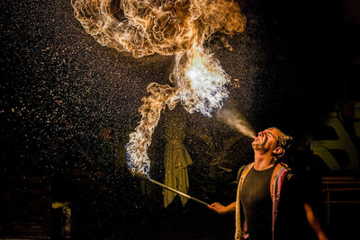 Young man standing against sky at night