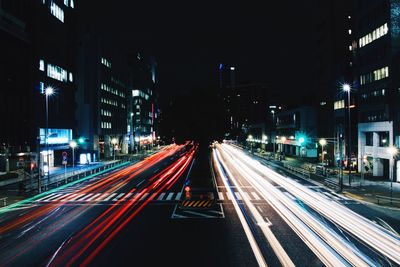 Light trails on road along buildings at night