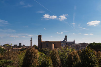 Panoramic view of trees and buildings against sky