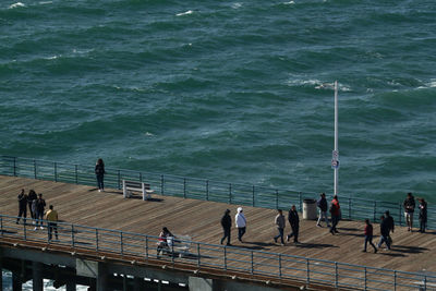 High angle view of people standing by sea