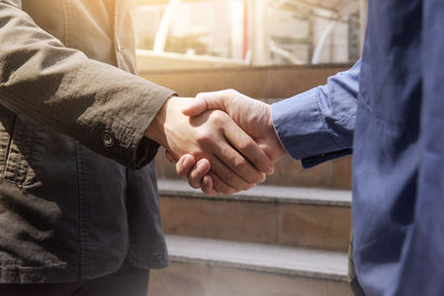 Midsection of businessman shaking hands