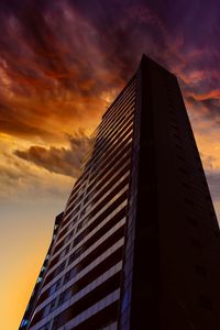 Low angle view of modern building against sky during sunset