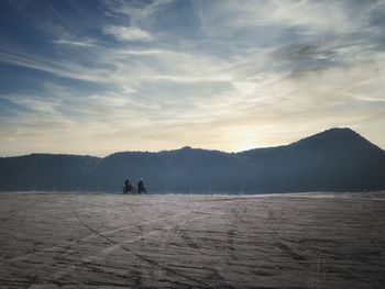 People on snowcapped mountains against sky