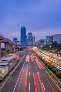 High angle view of light trails on city street amidst buildings